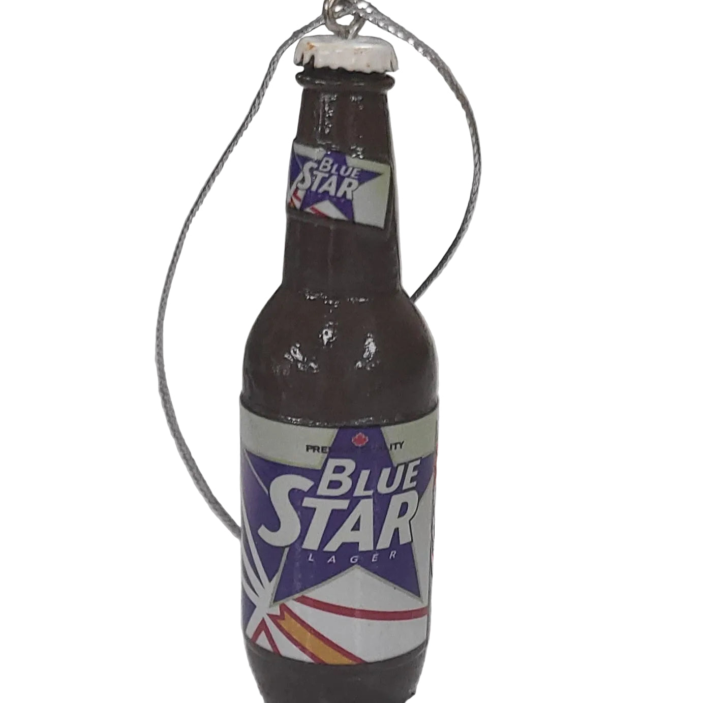 Blue Star Lager bottle-shaped ornament on a gray surface with a blurred background