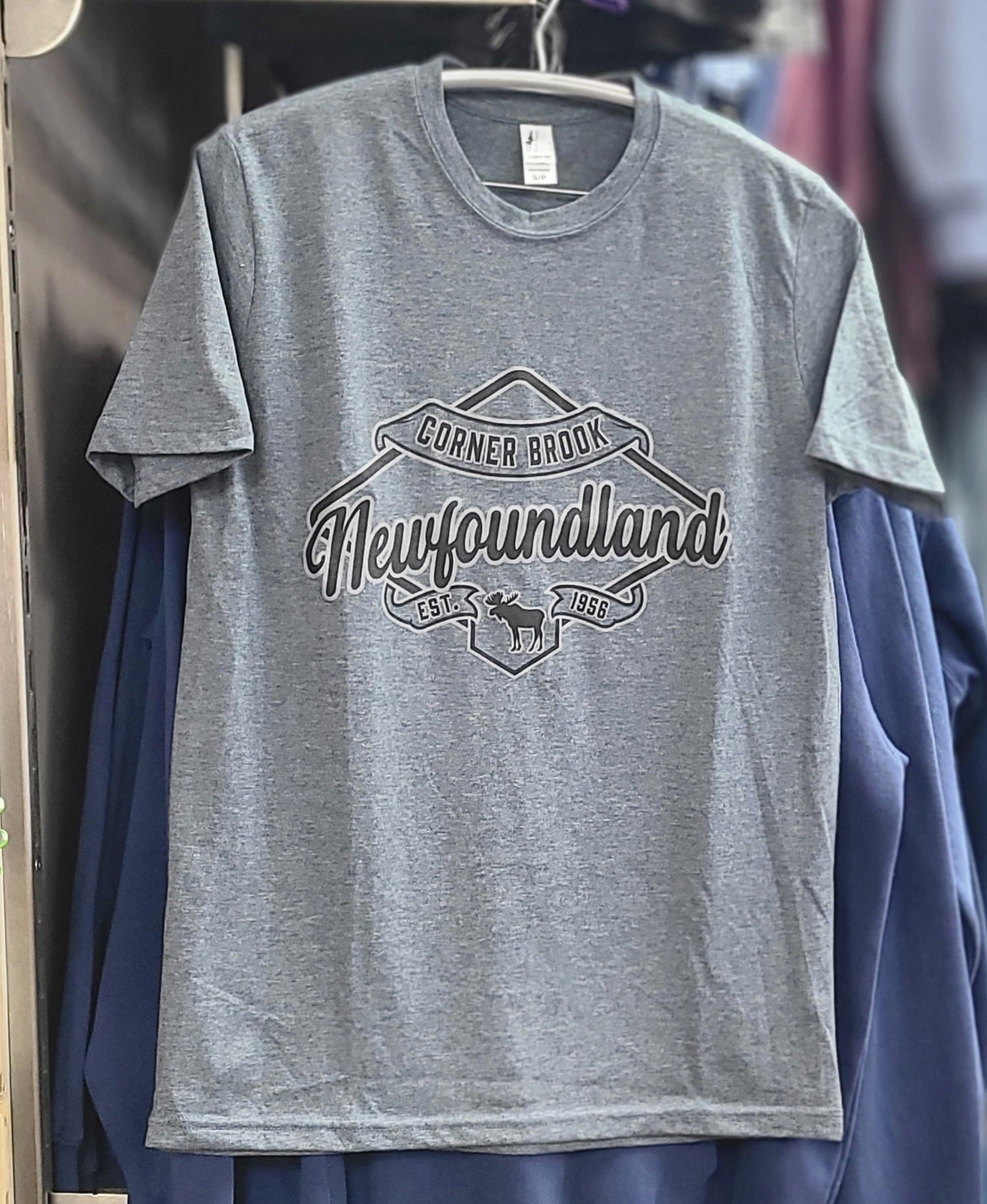Gray t-shirt with 'Corner Brook Newfoundland' print on a hanger