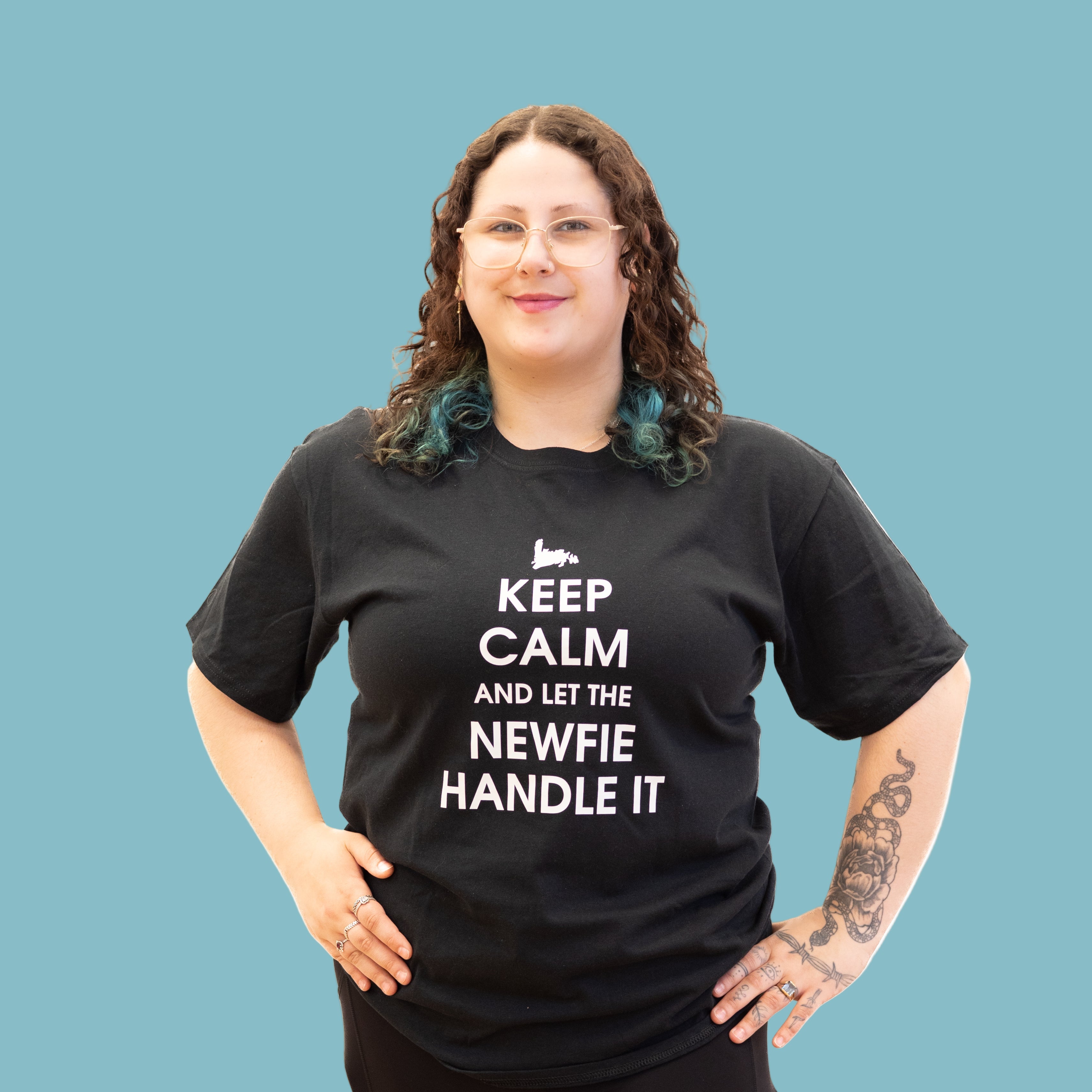 Model wearing black Newfie Handle It T-shirt with slogan “Keep Calm and Let the Newfie Handle It.