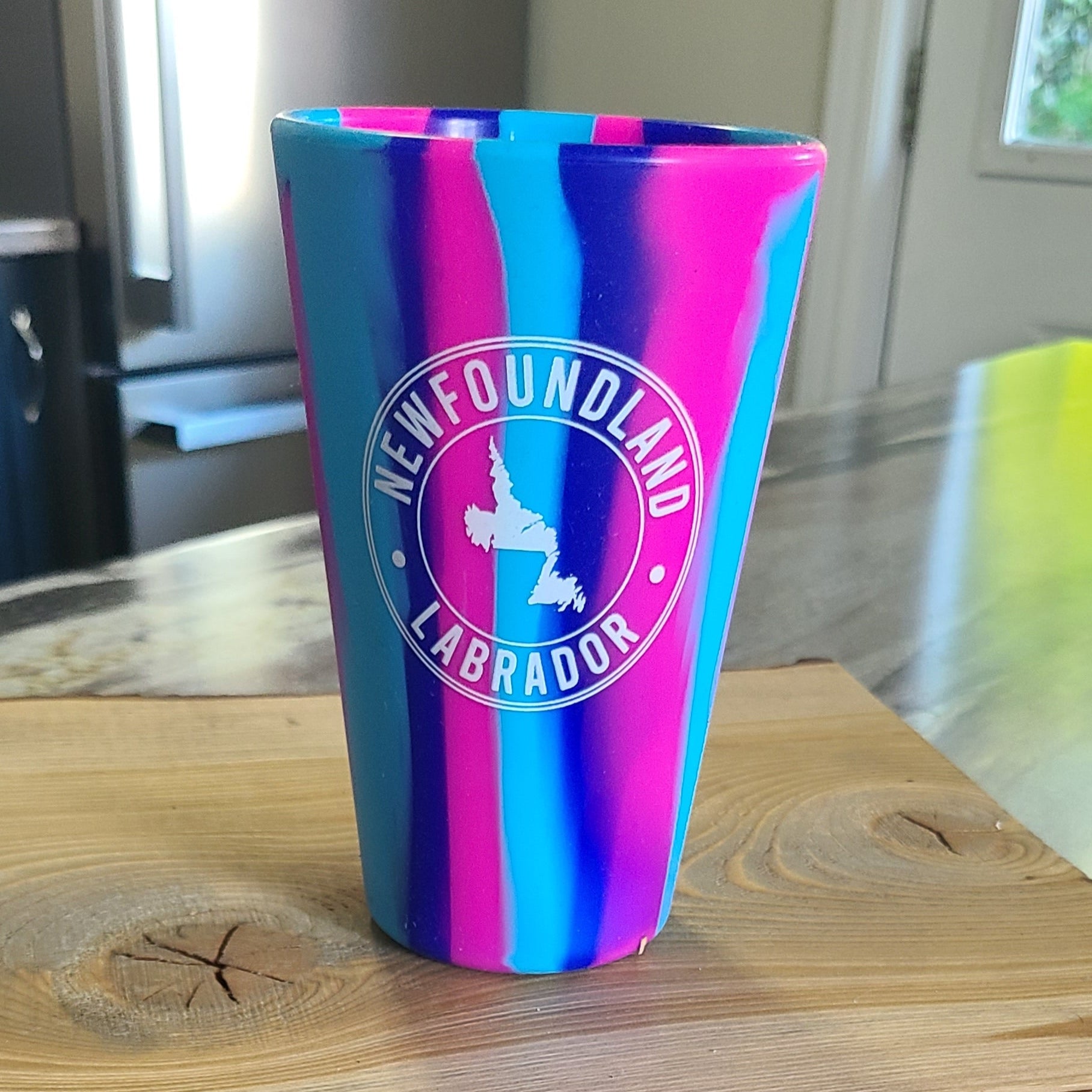 Funky NL Silicone Glass with Newfoundland logo on wooden board