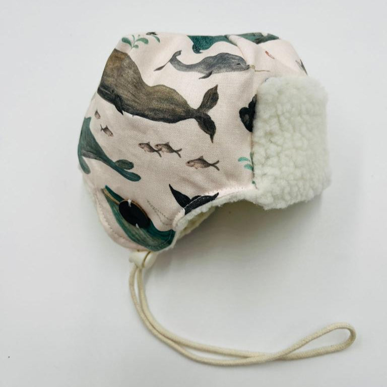 Children's Pilot Hat with famous Newfoundland whale pattern and white fleece trim on a light grey background
