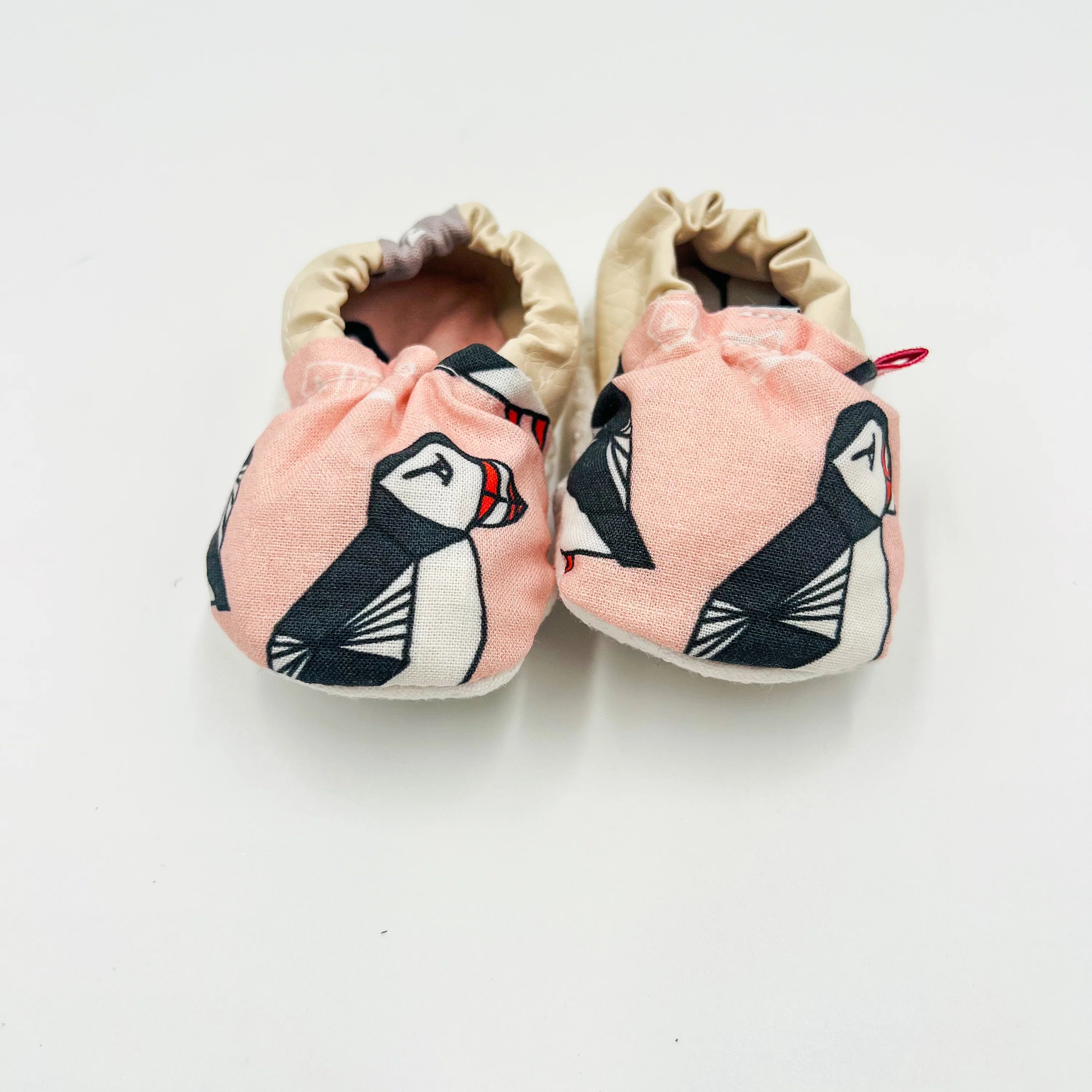 Pink Newfoundland puffin-print baby summer shoes with beige heel, front view.