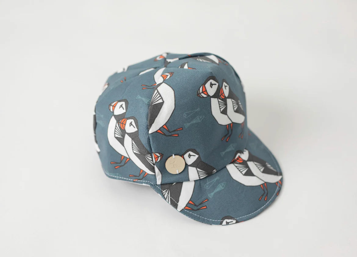 Toddler's baseball cap with Newfoundland's famous puffin pattern on a light grey background