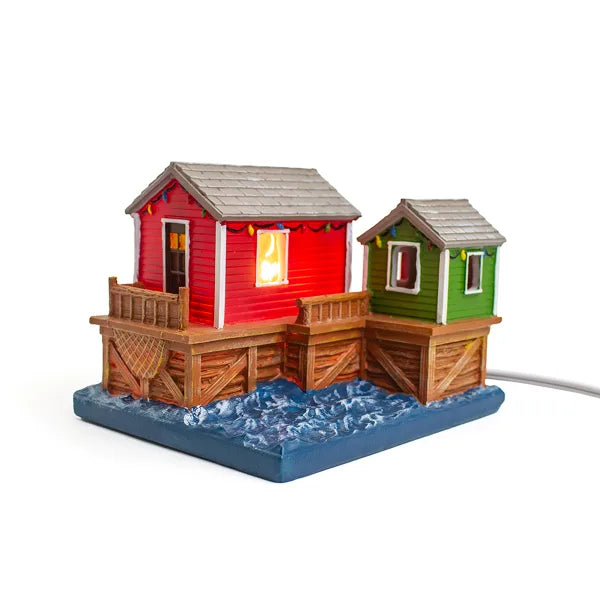 Colorful-toy-boat-houses-on-a-base -with-water-effect-on-a-white background