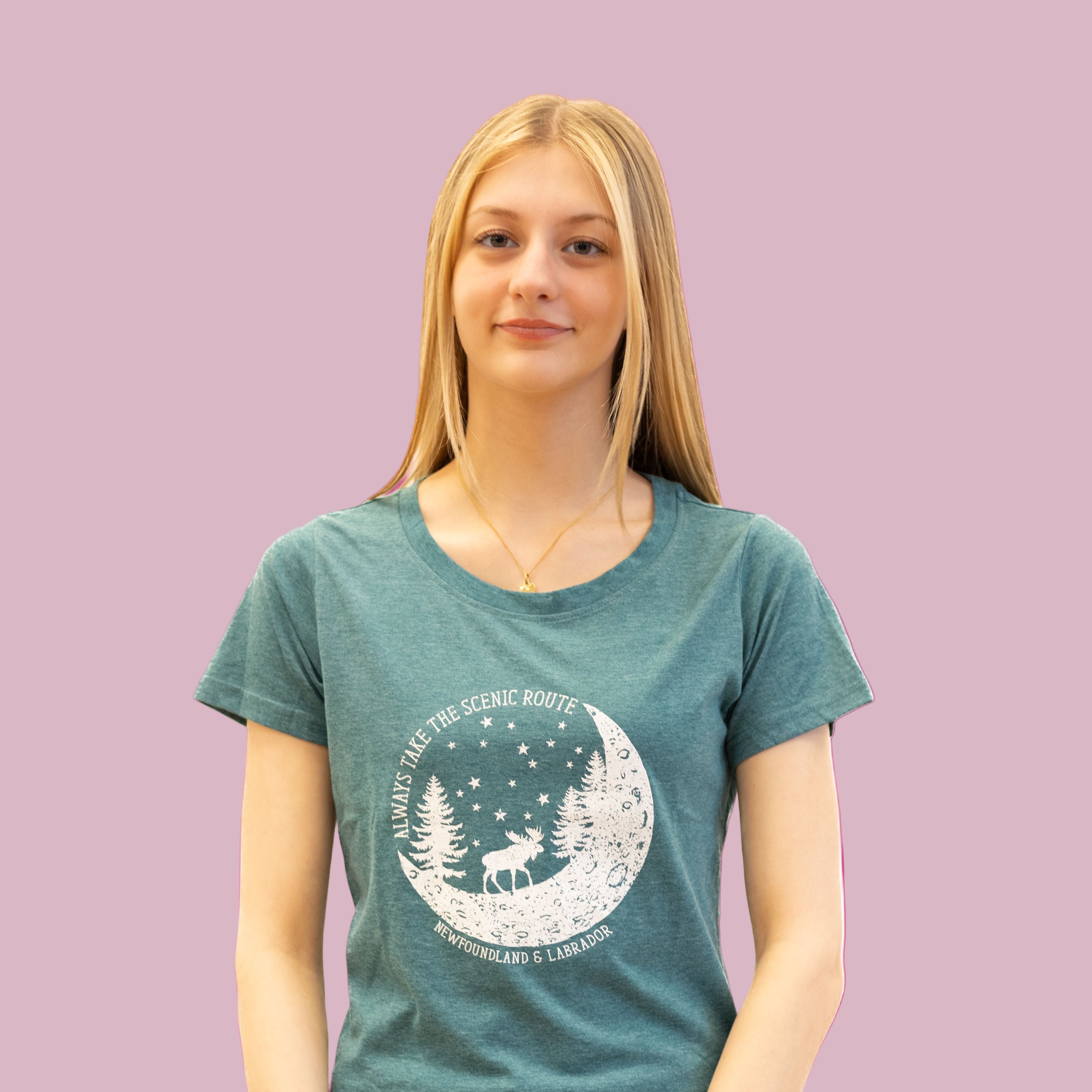 Woman wearing teal Scenic Route Tee with moonlit moose and forest design, Newfoundland & Labrador shirt.