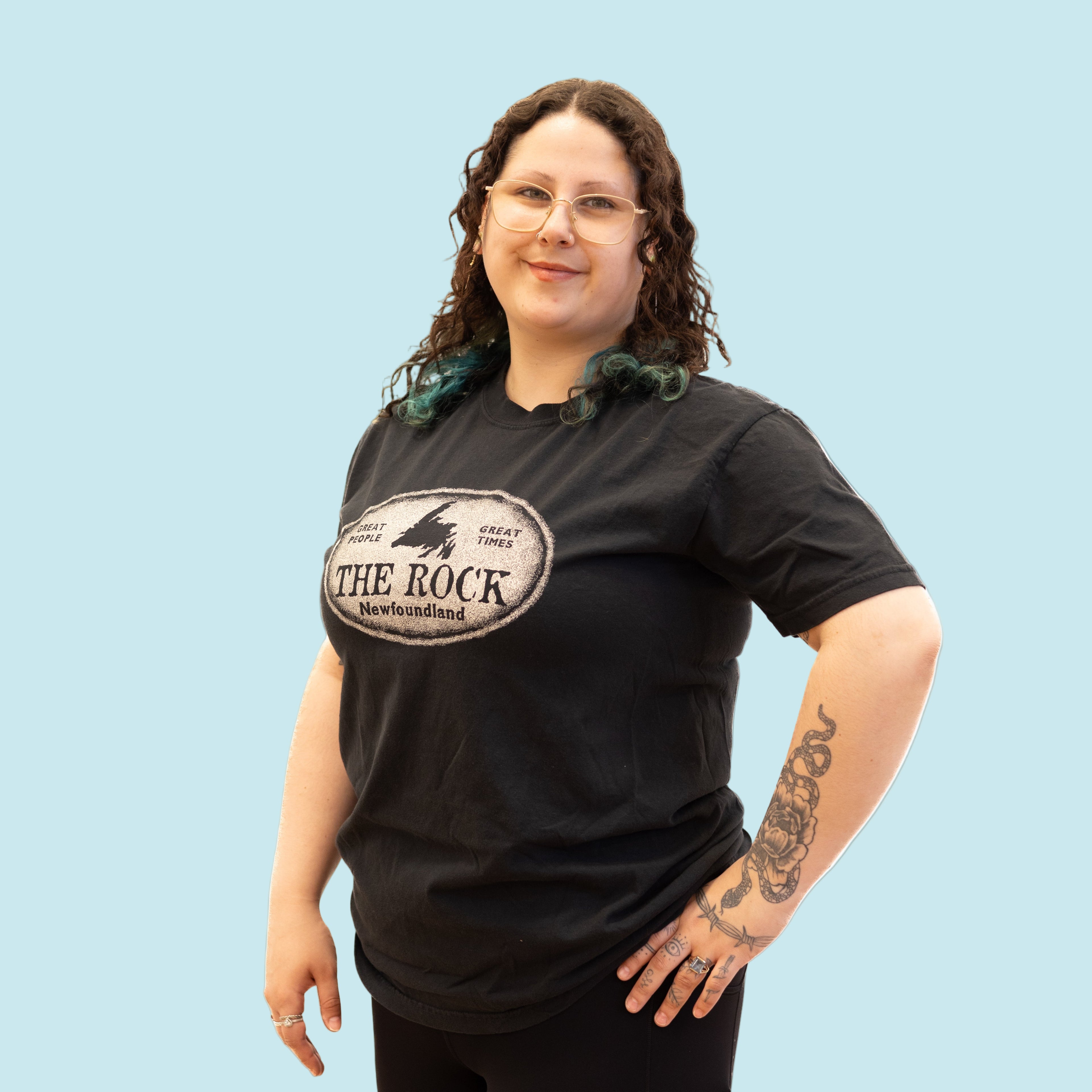 Person wearing a black t-shirt with 'The Rock Newfoundland' logo on a white background