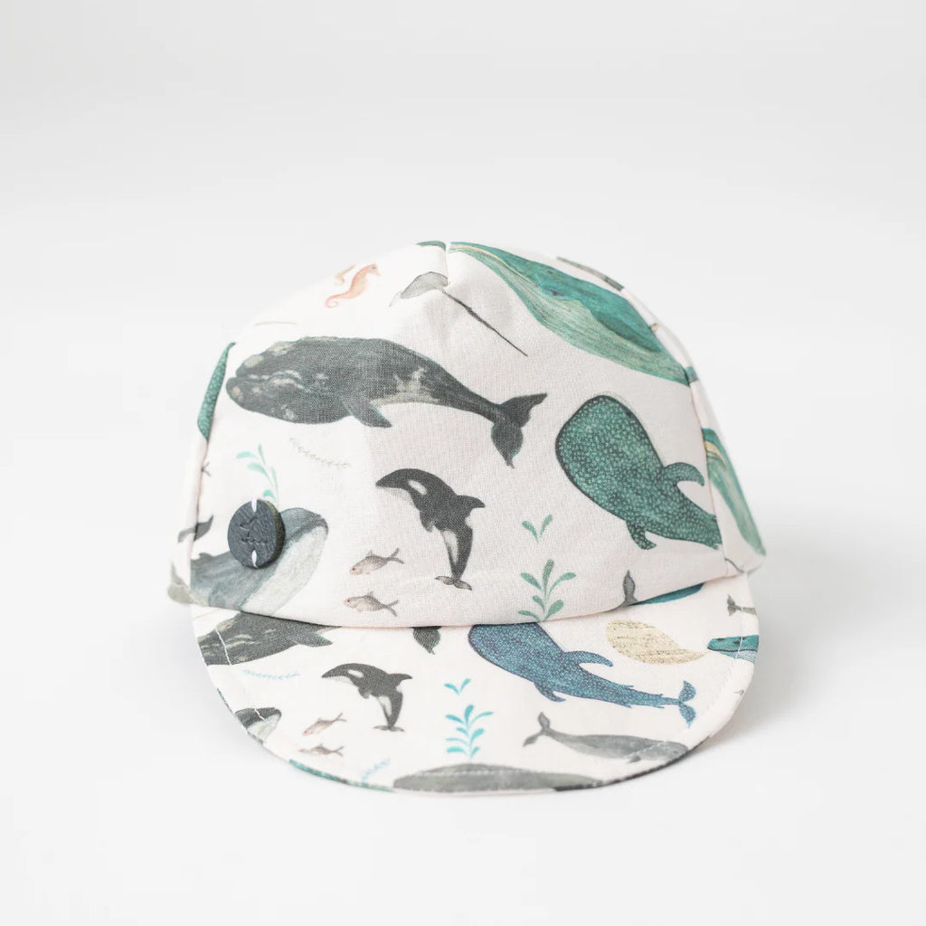 Infant Whale Baseball Cap decorated with famous Newfoundland whales and narwhals, front view.
