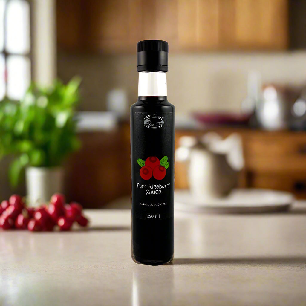 Tall bottle of Partridgeberry Sauce on a kitchen counter with blurred background