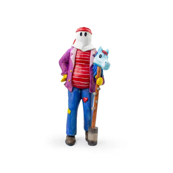 Colourful figurine of a Newfoundland Christmas mummer holding a blue hobby horse, dressed in a striped shirt, purple jacket, patched trousers.